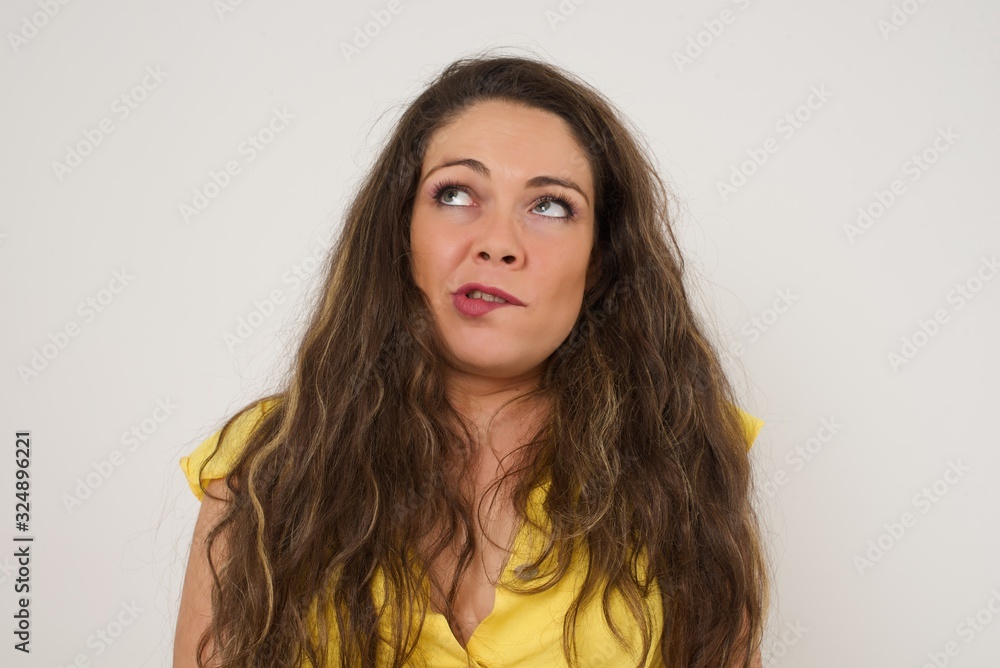 Beautiful young woman nervous and scared biting lips looking camera with impatient expression, pensive� Beautiful young woman nervous and scared biting lips looking camera with impatient expression, pensive�