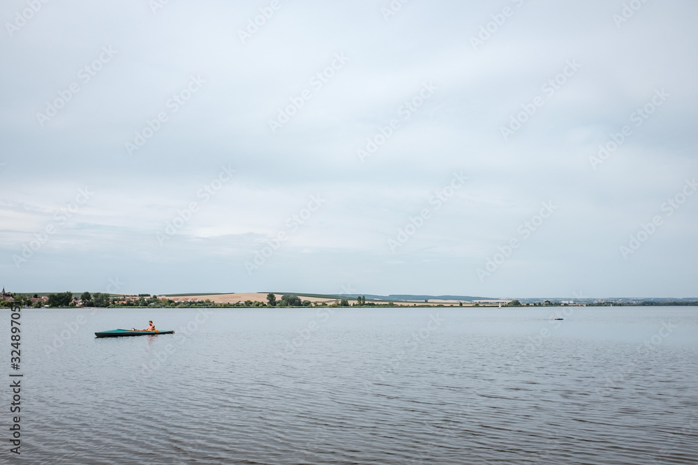 Wide view of a lake with canoeists.