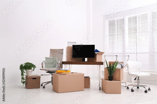 Cardboard boxes and packed belongings in office. Moving day © New Africa