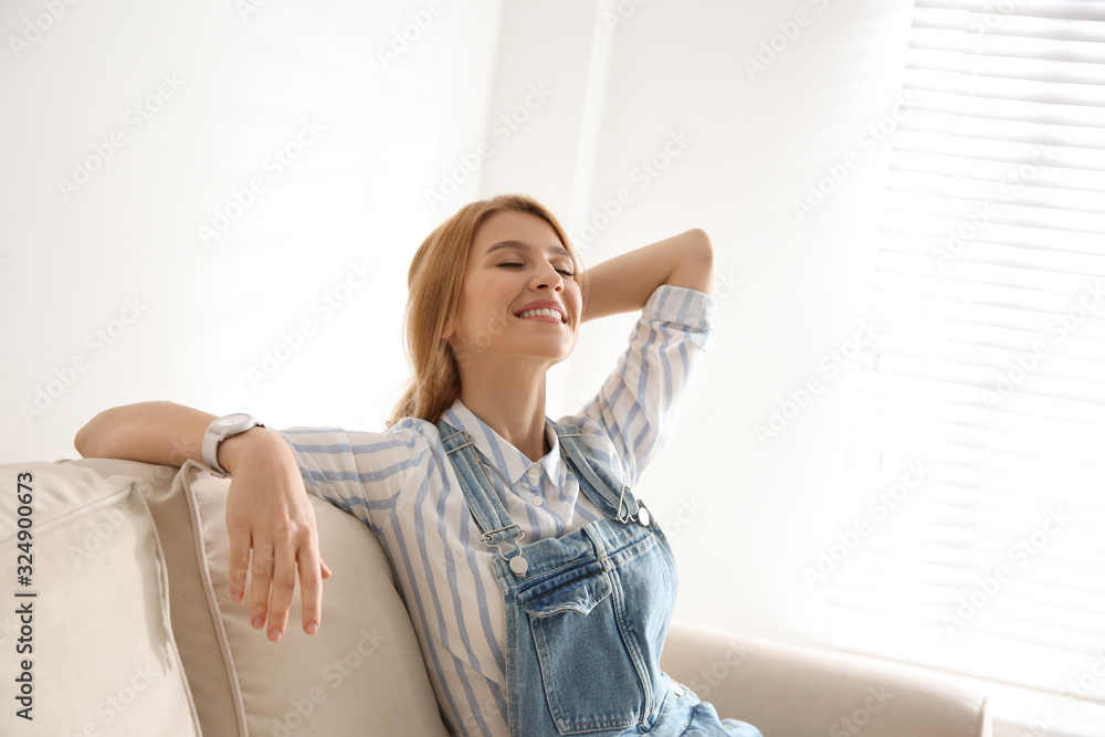 Young woman relaxing on couch near window at home