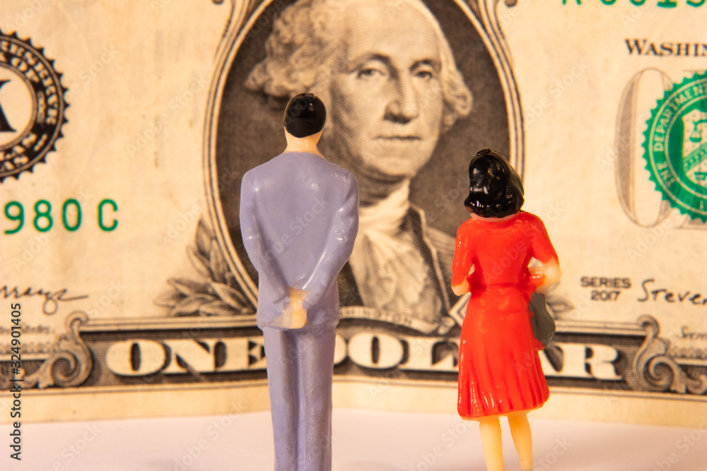 Miniature figure male and female gazing at a dollar bill