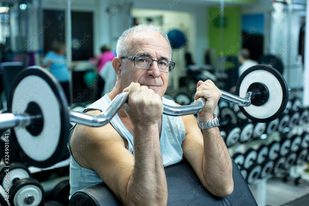 Uomo anziano fa degli esercizi con i pesi in palestra Stock Photo ...