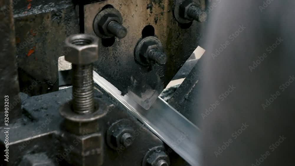 Man working cutting angle steel by Hydraulic Ironworker cutting machine in factory. Old industry concept. Man working cutting angle steel by Hydraulic Ironworker cutting machine in factory. Old industry concept.