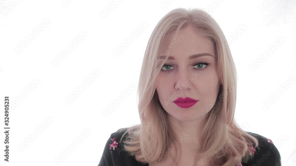 Attractive young blonde woman with red lips looking into the camera and plays with her hair. Temptation, beauty. White background. Sexy look Attractive young blonde woman with red lips looking into the camera and plays with her hair. Temptation, beauty. White background. Sexy look