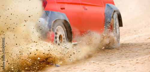 Gravel splashing from rally race car drift on track. © toa555