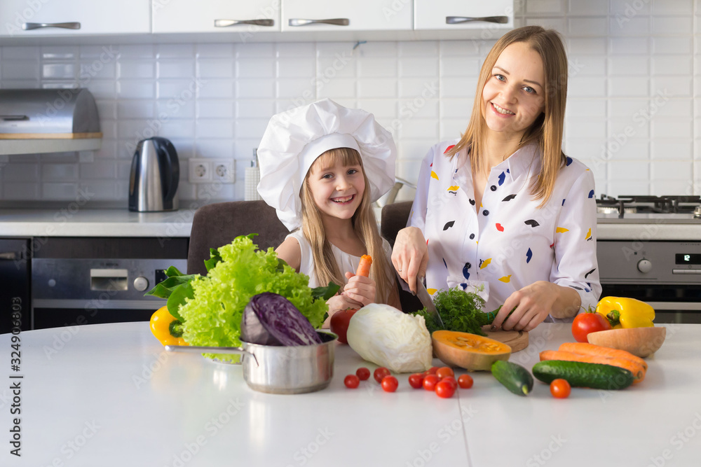 Mother and daughter, white chef hat, vegetables Mother and daughter, white chef hat, vegetables