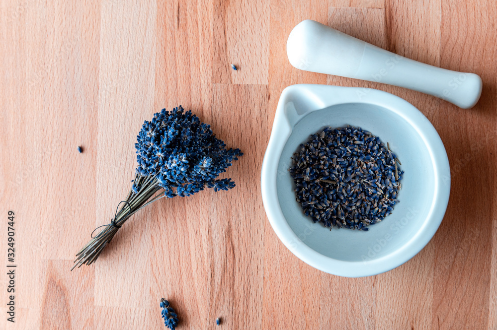 Top view of mortar and pestle with lavender flowers on wood table background. Natural cosmetic Top view of mortar and pestle with lavender flowers on wood table background. Natural cosmetic