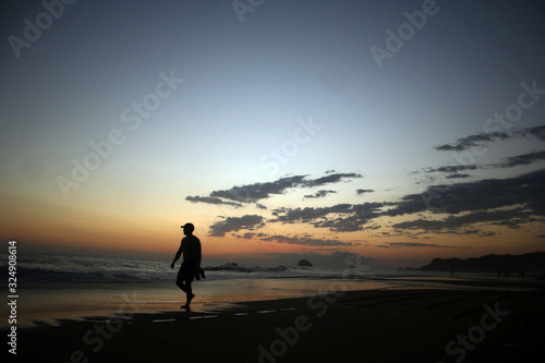 silhouette of young woman on a beach at sunset