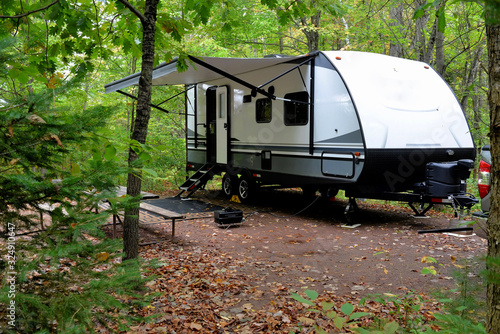 Fototapeta Travel trailer camping in the woods