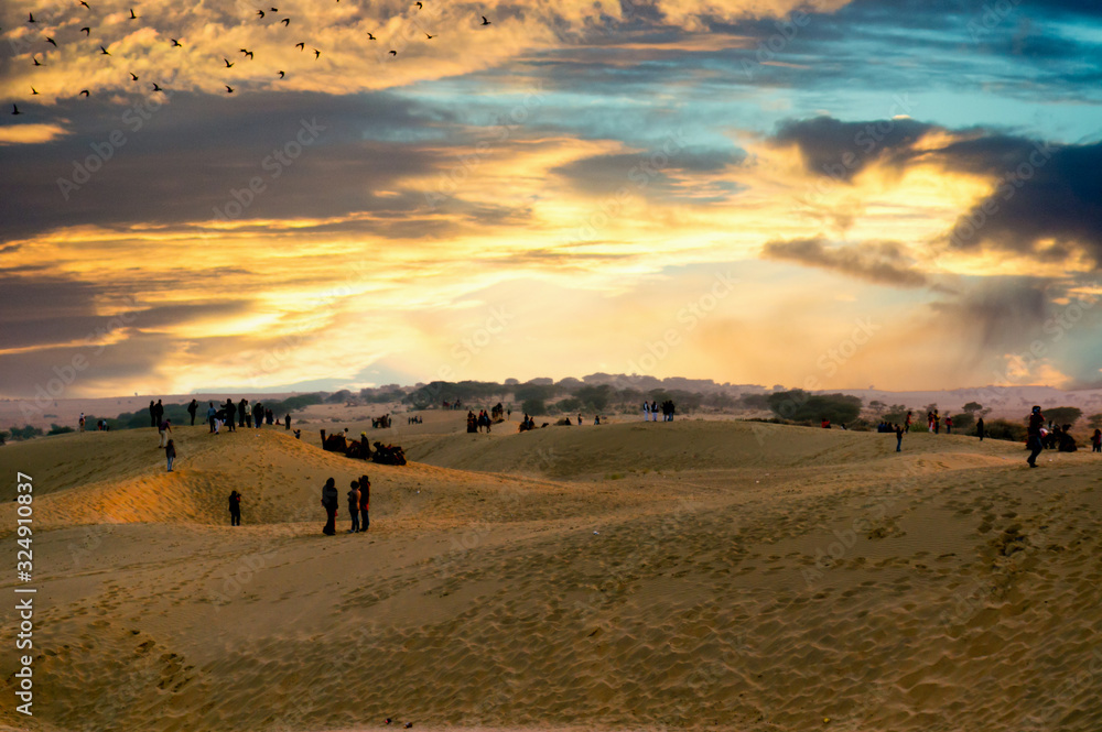 People enjoying the sunset on sand dunes People enjoying the sunset on sand dunes