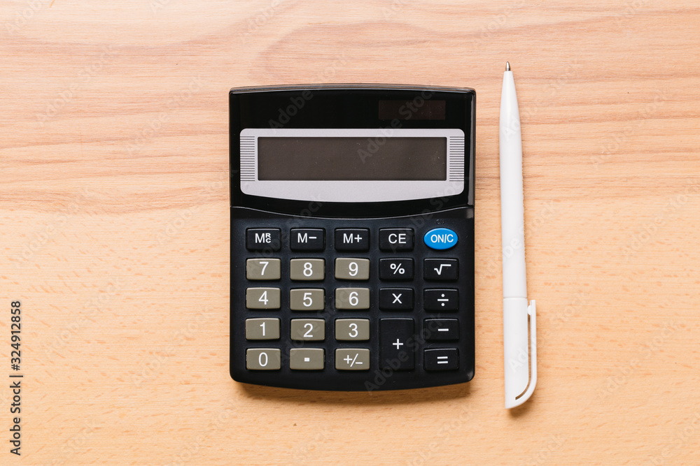 Accounting, financial concept, flat lay, calculator and pen on wooden table Accounting, financial concept, flat lay, calculator and pen on wooden table