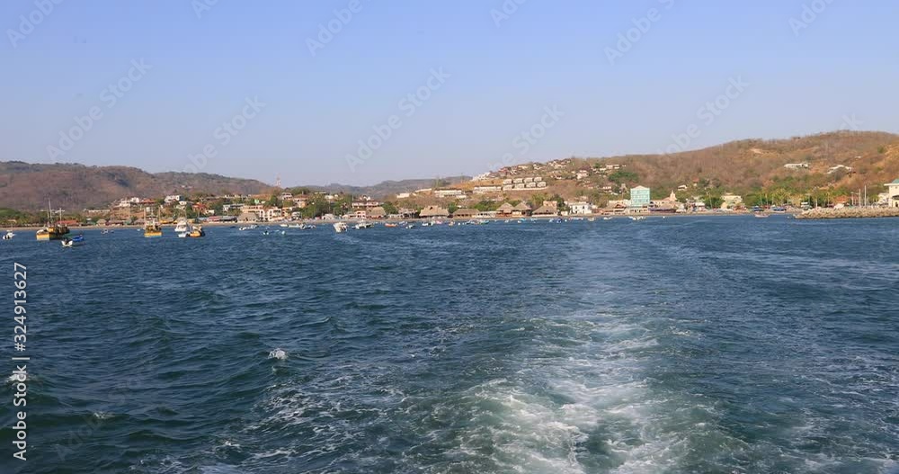 Nicaragua San Juan del Sur city from back moving boat POV. Tourist destination with tropical beach and resorts. Cultural traditions, diversity in folklore, cuisine and culture. Poor population. Nicaragua San Juan del Sur city from back moving boat POV. Tourist destination with tropical beach and resorts. Cultural traditions, diversity in folklore, cuisine and culture. Poor population.