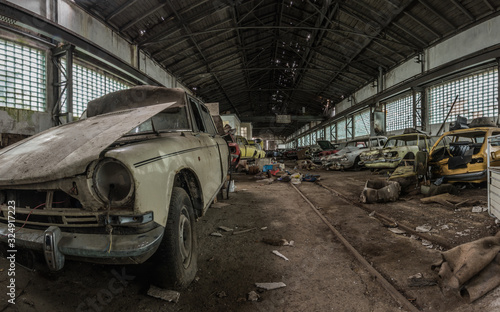 viele zerlegte autos in einer halle panorama