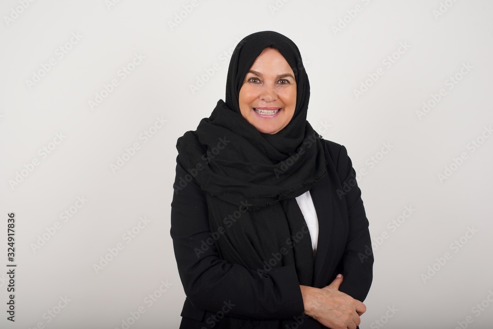 Positive human facial expressions and emotions. Isolated shot of attractive muslim woman looking and smiling broadly at camera during nice conversation with someone. Positive human facial expressions and emotions. Isolated shot of attractive muslim woman looking and smiling broadly at camera during nice conversation with someone.