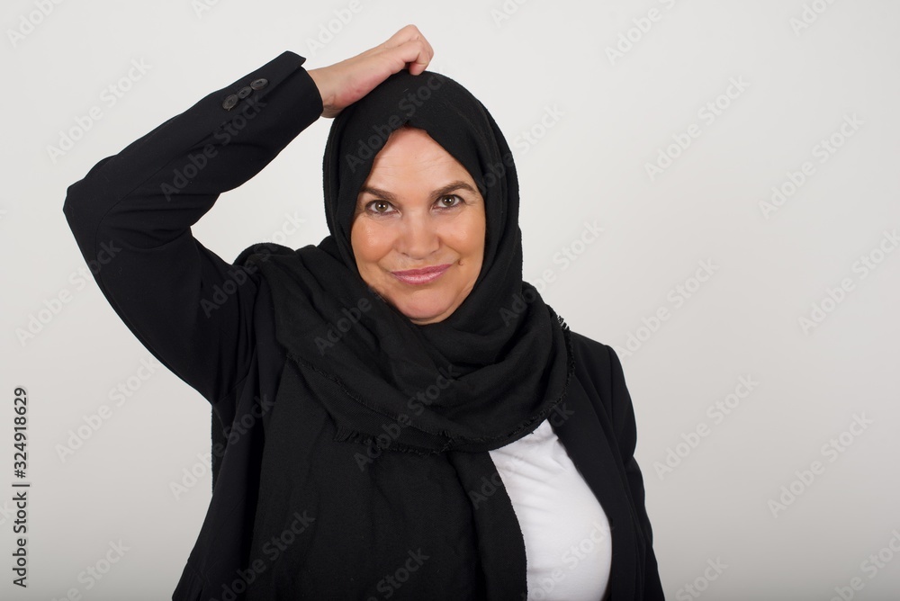 Oops, what did I do? Beautiful muslim woman holding hand on head with frightened and regret expression. Wearing casual clothes standing against gray background. Oops, what did I do? Beautiful muslim woman holding hand on head with frightened and regret expression. Wearing casual clothes standing against gray background.
