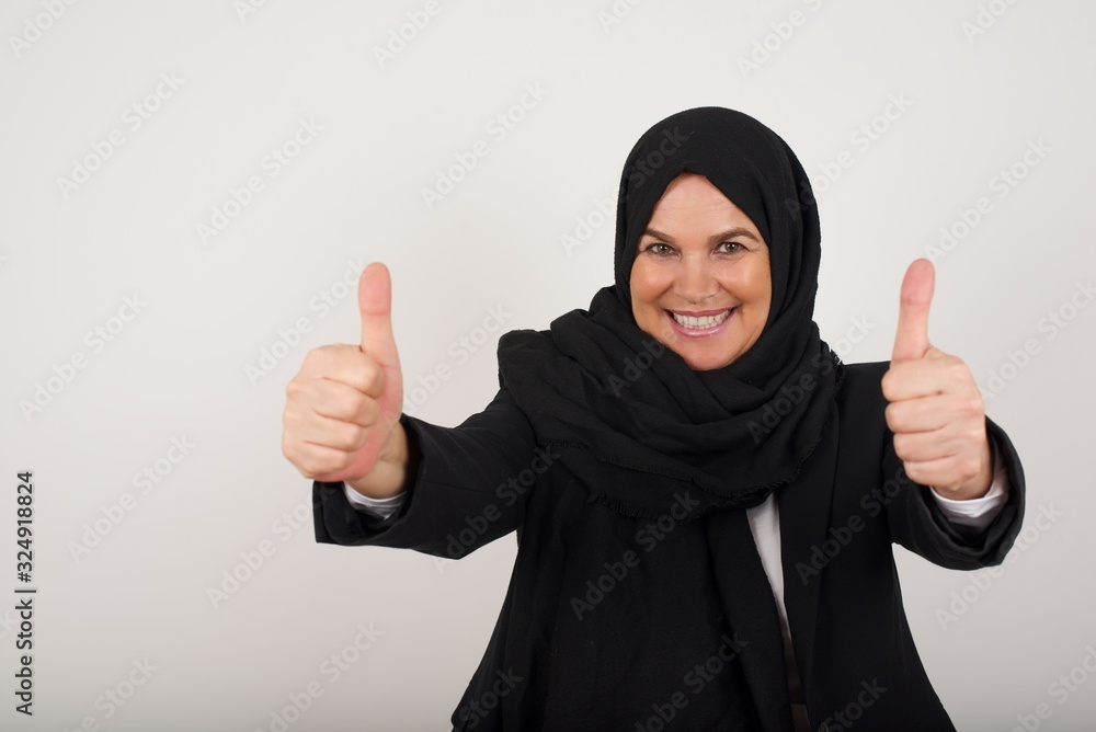 Young blonde woman over isolated background approving doing positive gesture with hand, thumbs up smiling and happy for success. Looking at the camera, winner gesture. Young blonde woman over isolated background approving doing positive gesture with hand, thumbs up smiling and happy for success. Looking at the camera, winner gesture.