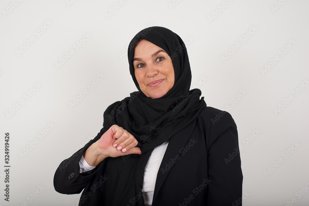 Closeup of cheerful beautiful European muslim woman looks joyful, satisfied and confident, points at herself with thumb, isolated over studio background. Closeup of cheerful beautiful European muslim woman looks joyful, satisfied and confident, points at herself with thumb, isolated over studio background.