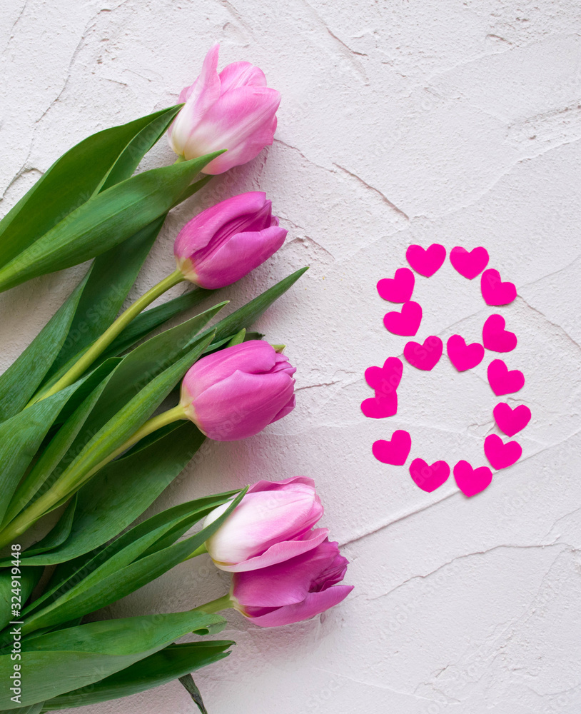 Beautiful spring tulips and hearts in the shape of eight on grey stone background. Concept of Valentines day, Women's Day March eight, Mothers day. Space for text, flat lay. Beautiful spring tulips and hearts in the shape of eight on grey stone background. Concept of Valentines day, Women's Day March eight, Mothers day. Space for text, flat lay.