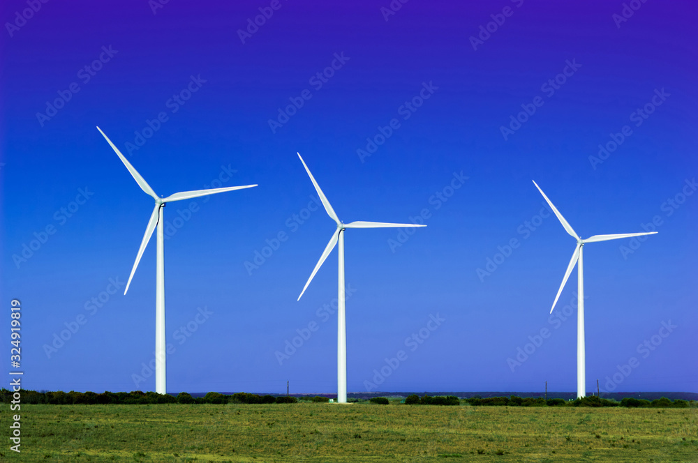A group of wind turbines with blue sky background