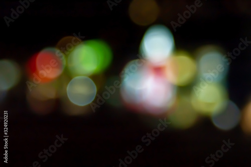 Bokeh neon sparkling shop windows. Blurred image of neon light in a shop window at night in the city. Bokeh elements. © Alex Puhovoy