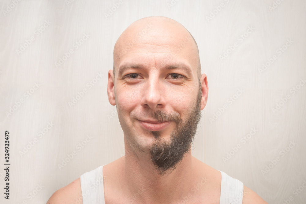 Fototapeta premium A man's face with a full beard and no beard. Portrait of a bald young man with cheerful smiles. Funny concept of duplicity.