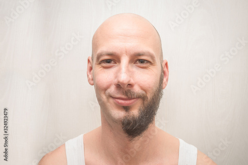 A man's face with a full beard and no beard. Portrait of a bald young man with cheerful smiles. Funny concept of duplicity. photo