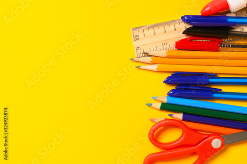 Assorted school supplies on a yellow background