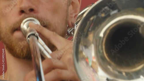 trombonist musician is playing on trombone close up