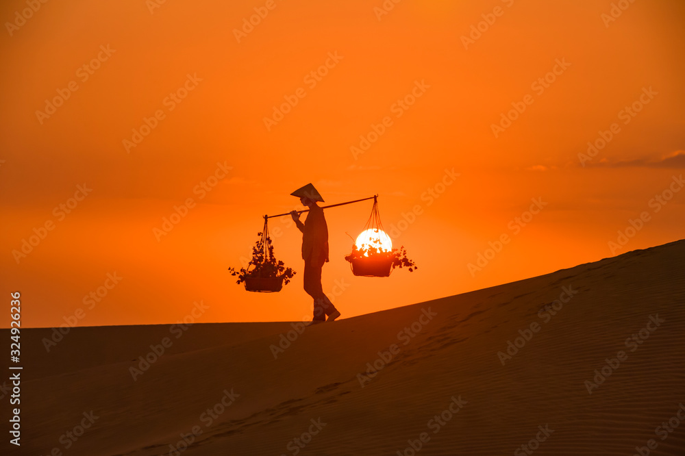 Silhouette of a hawker merchant traveling through the mui ne desert in Vietnam