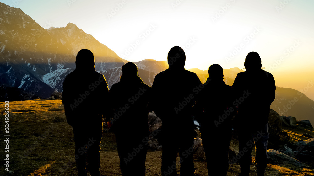 silhouettes of people on top of the mountain