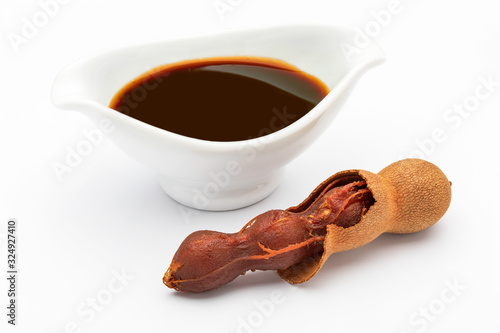 Tamarind sauce (tropical fruit). With shell, with visible seeds and inner pulp. Isolated on white background