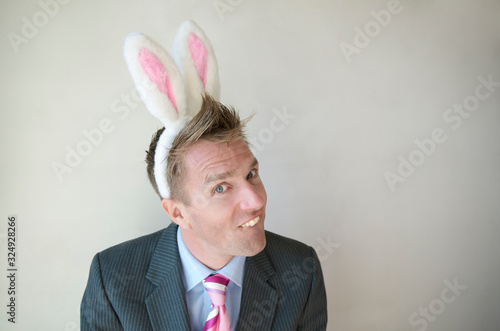 Man wearing Easter bunny ears baring buck teeth with copy space  © PeskyMonkey