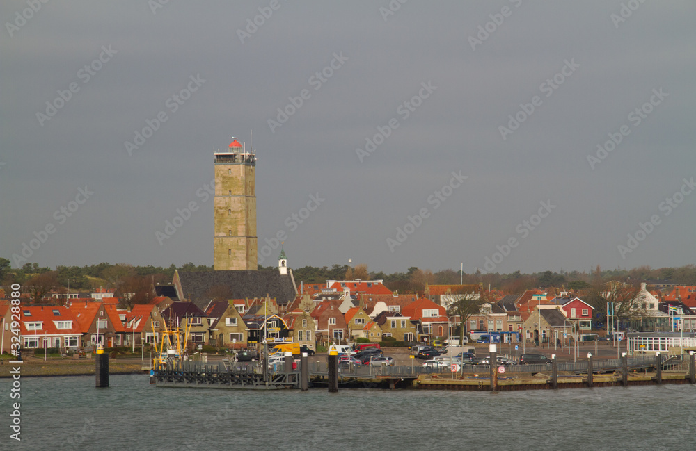 View from the sea on the harbour and lighthouse of the Dutch island Terschelling