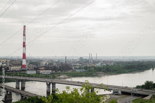 a bridge stretches across the river to an industrial city