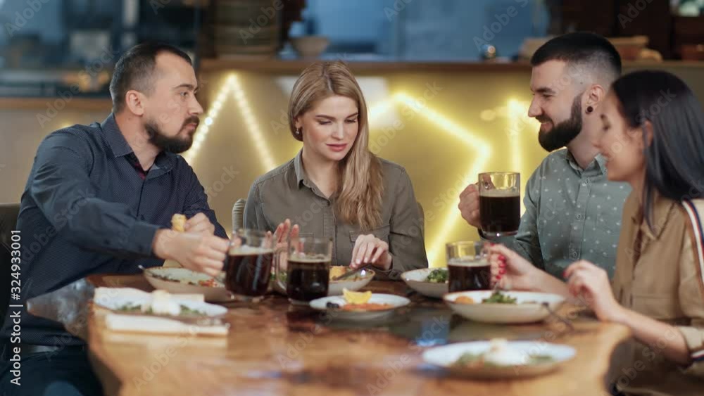 Positive people enjoying fresh food and drink refreshing foamy beer. Shot with RED camera in 4K Positive people enjoying fresh food and drink refreshing foamy beer. Shot with RED camera in 4K