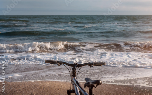 Bicycle stands on the shore against the background of a sea landscape at sunset. Bike ride. Seascape . Holidays by the sea . Walk along the beach