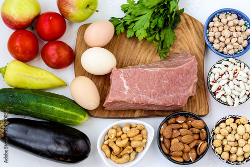 Flexitarian diet with fresh vegetables, raw meat, eggs, legumes, nuts, fruit on white background