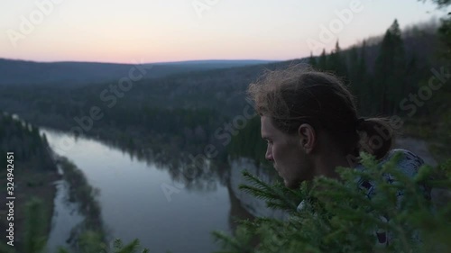 Person looking down at beautiful river valley from high point of mountains, closeup portrait shoot