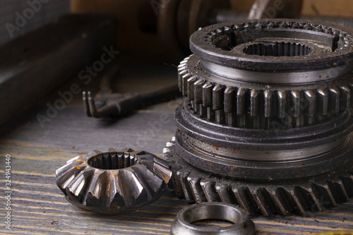 Several gears of a car gearbox on a wooden table close-up.