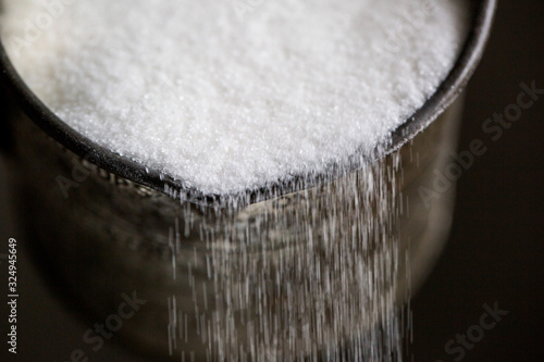 Castor sugar pouring from cup
