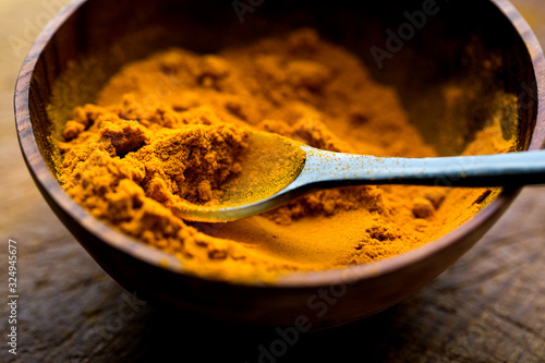 Close up view of turmeric in wooden bowl