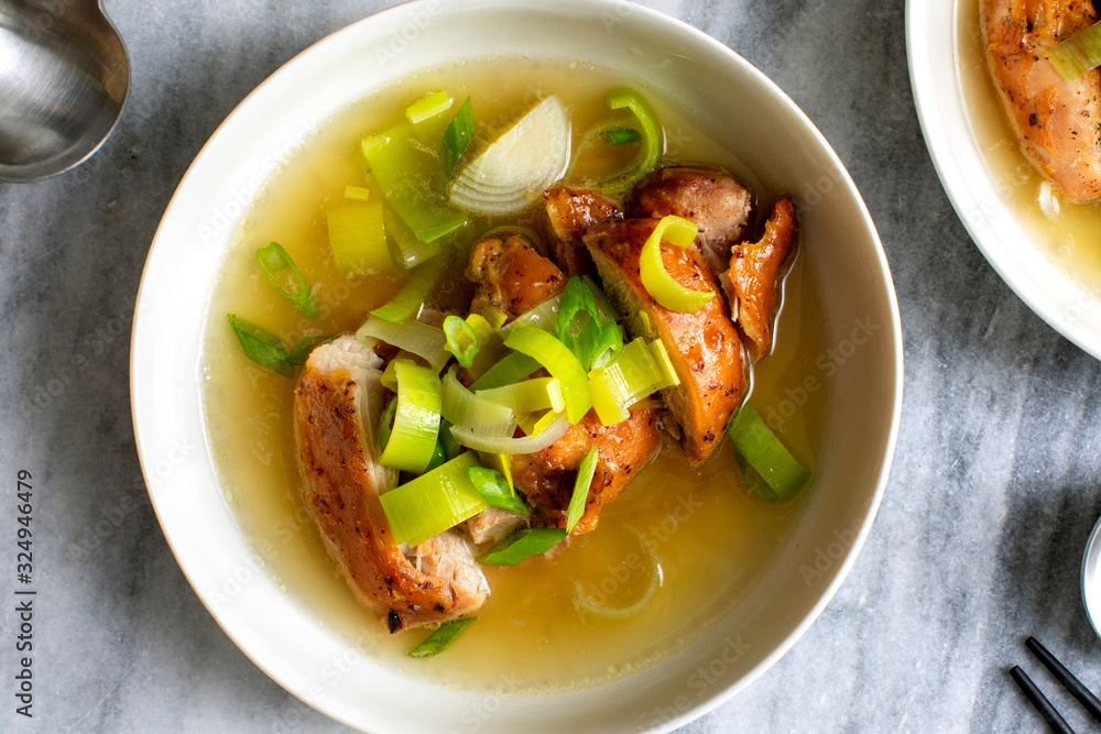 Miso chicken in ginger, leek and scallion broth served in bowl Miso chicken in ginger, leek and scallion broth served in bowl