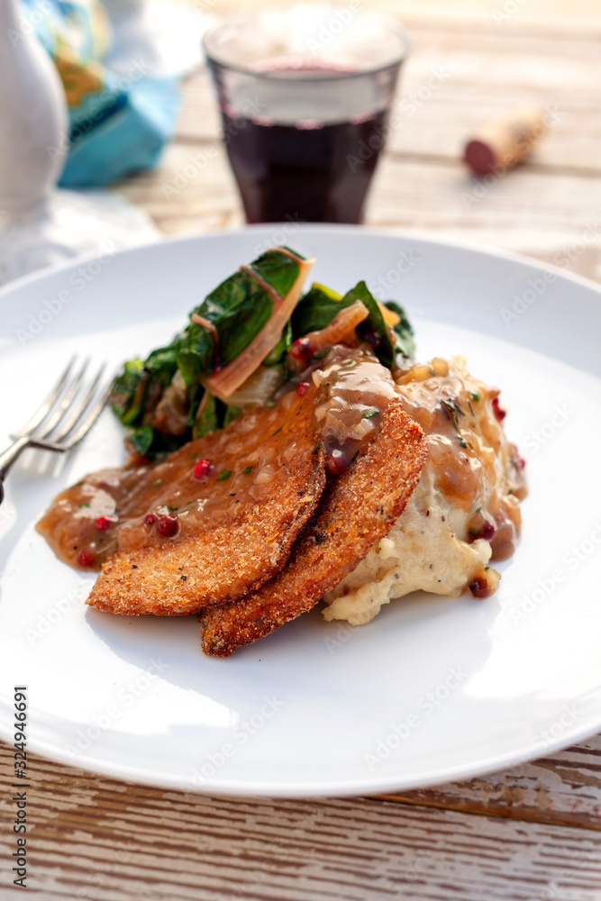 Tilt shift view of fried seitan with mashed potatoes and swiss chard Tilt shift view of fried seitan with mashed potatoes and swiss chard