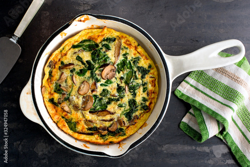 Overhead view of mushroom and spinach frittata in pan photo