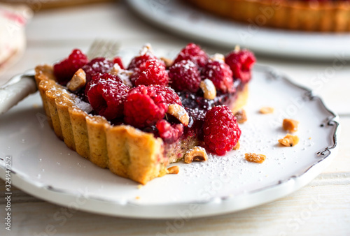 Selective focus of raspberry pie piece placed on wooden board