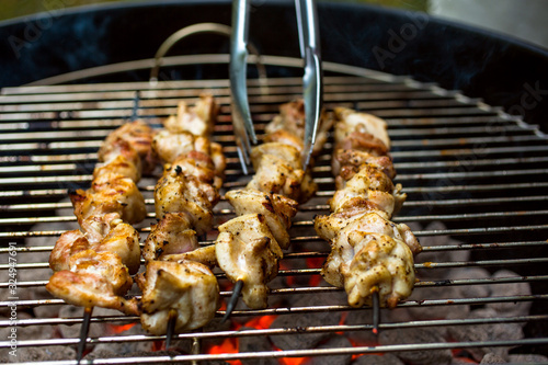 Close up view of barbecued chicken skewers on grill photo