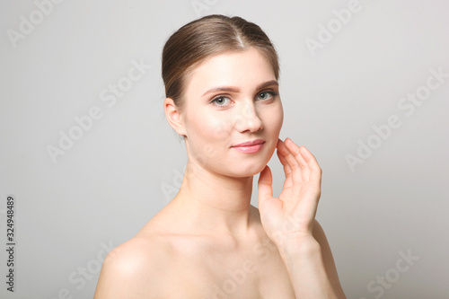 Portrait of a beautiful young girl with nude makeup on a light background. The concept of healthy and clean skin, skin care.