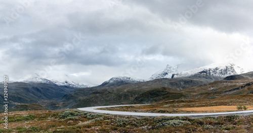 Mountain asphalt road, snow peaks Norway panorama