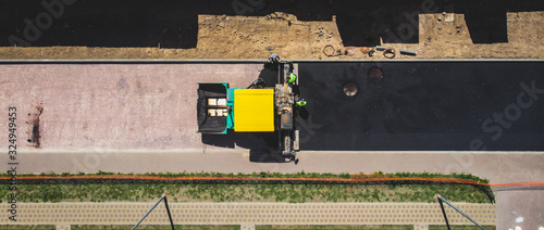 Asphalt paver machine and steam road roller during road construction and repairing works, process of asphalting and paving, workers working on the new road construction site, placing a layer, drone © tsuguliev