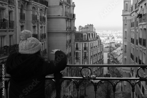 Girl admiring the views of Paris from a balcony in the Montmartre district